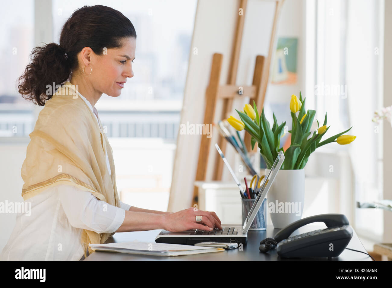 Hispanic woman typing on laptop Banque D'Images