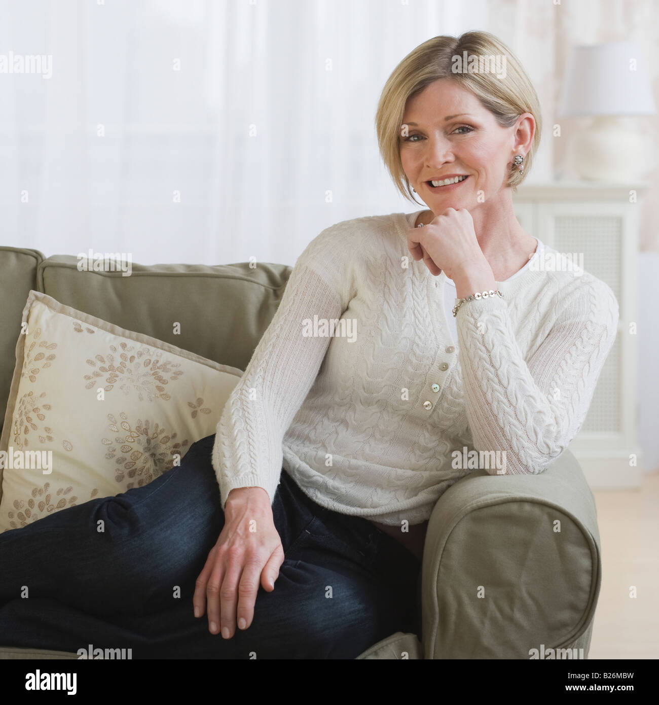 Woman sitting on sofa Banque D'Images