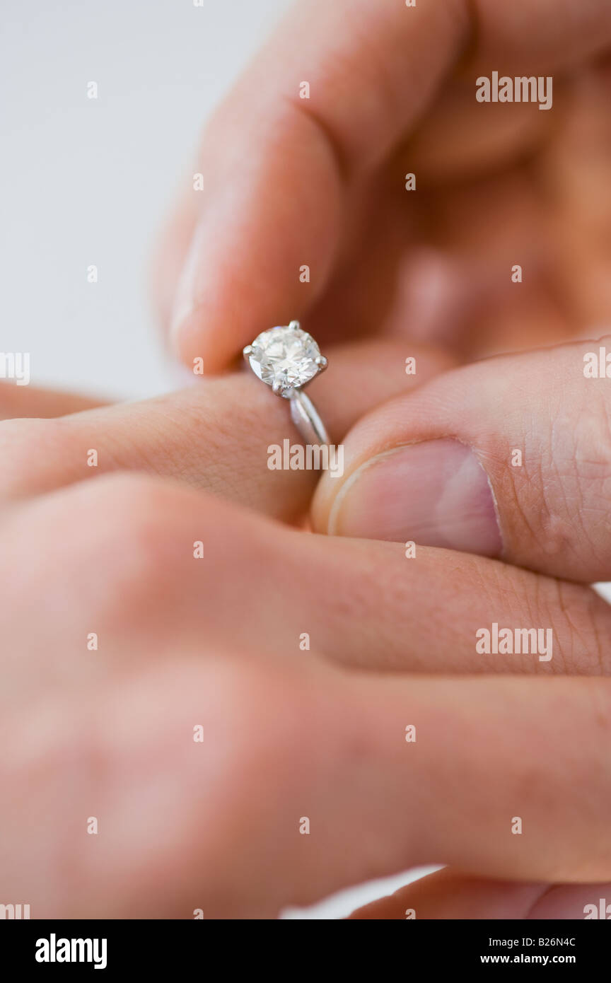 Man putting bague de fiançailles sur le doigt de femme Banque D'Images