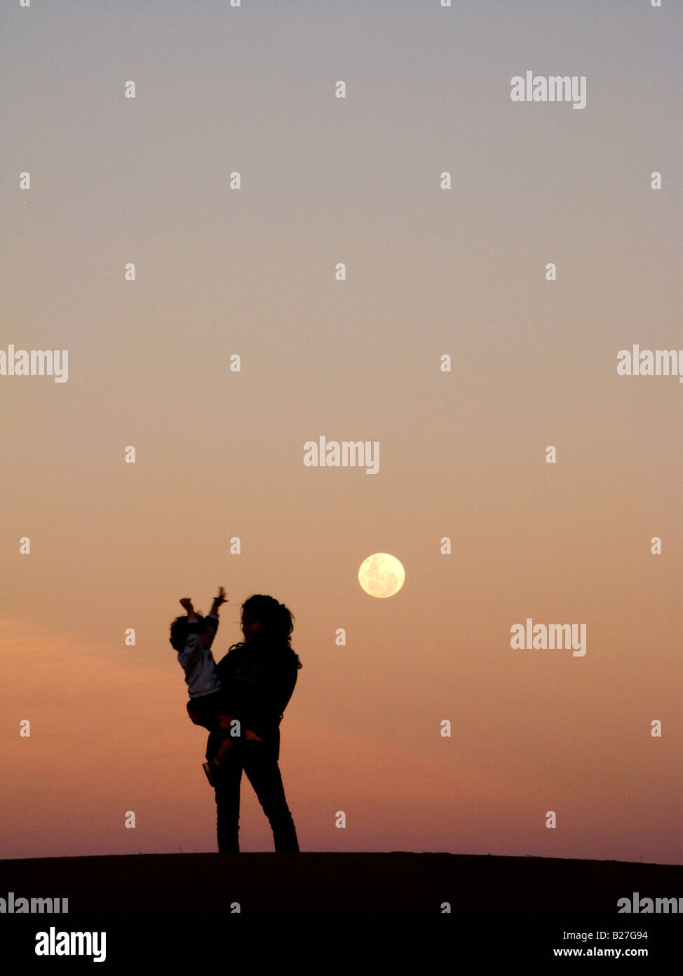 Silhouette d'une jeune femme et son petit fils avec la lune le ciel Banque D'Images