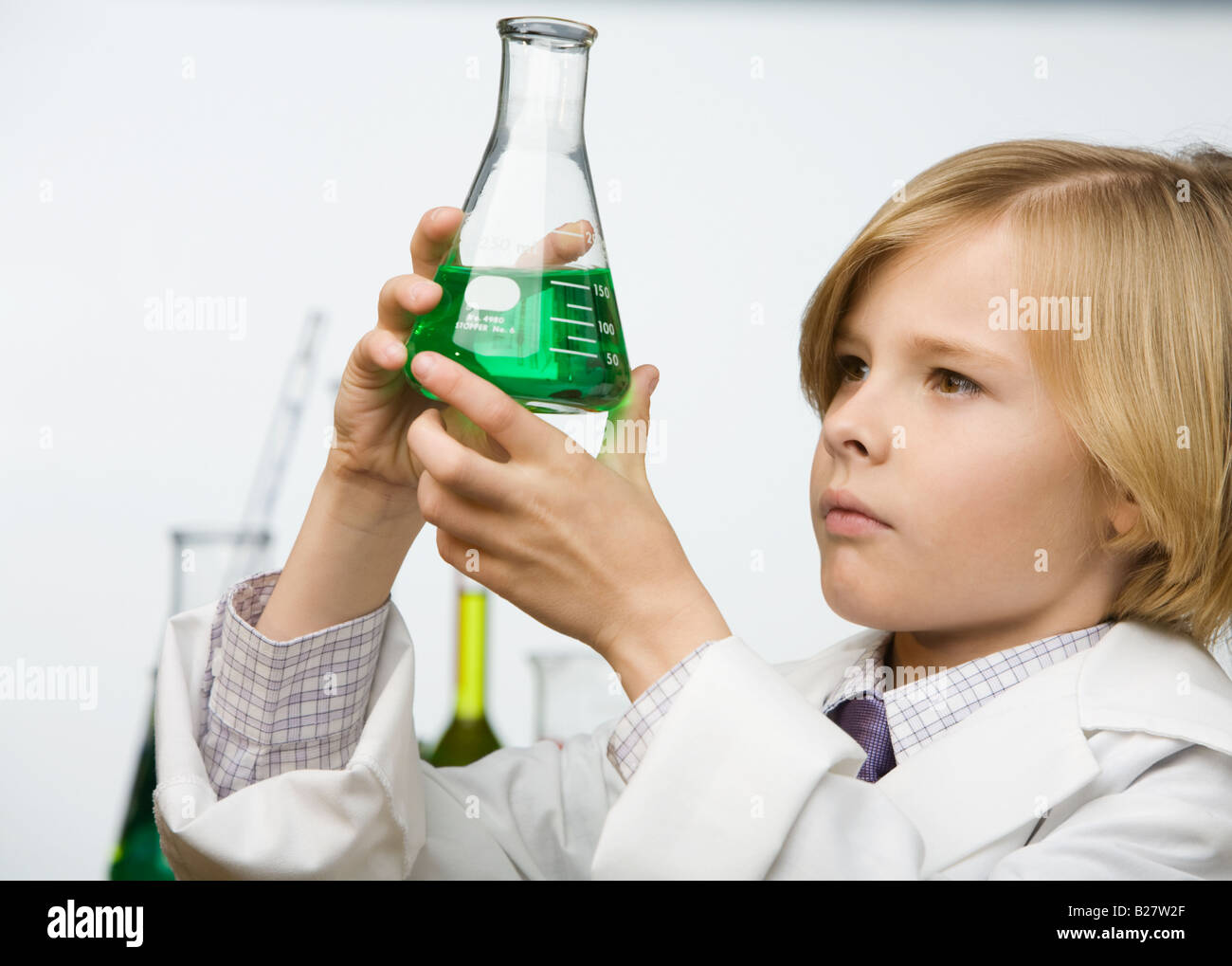 Boy looking at bécher rempli d'un liquide Banque D'Images
