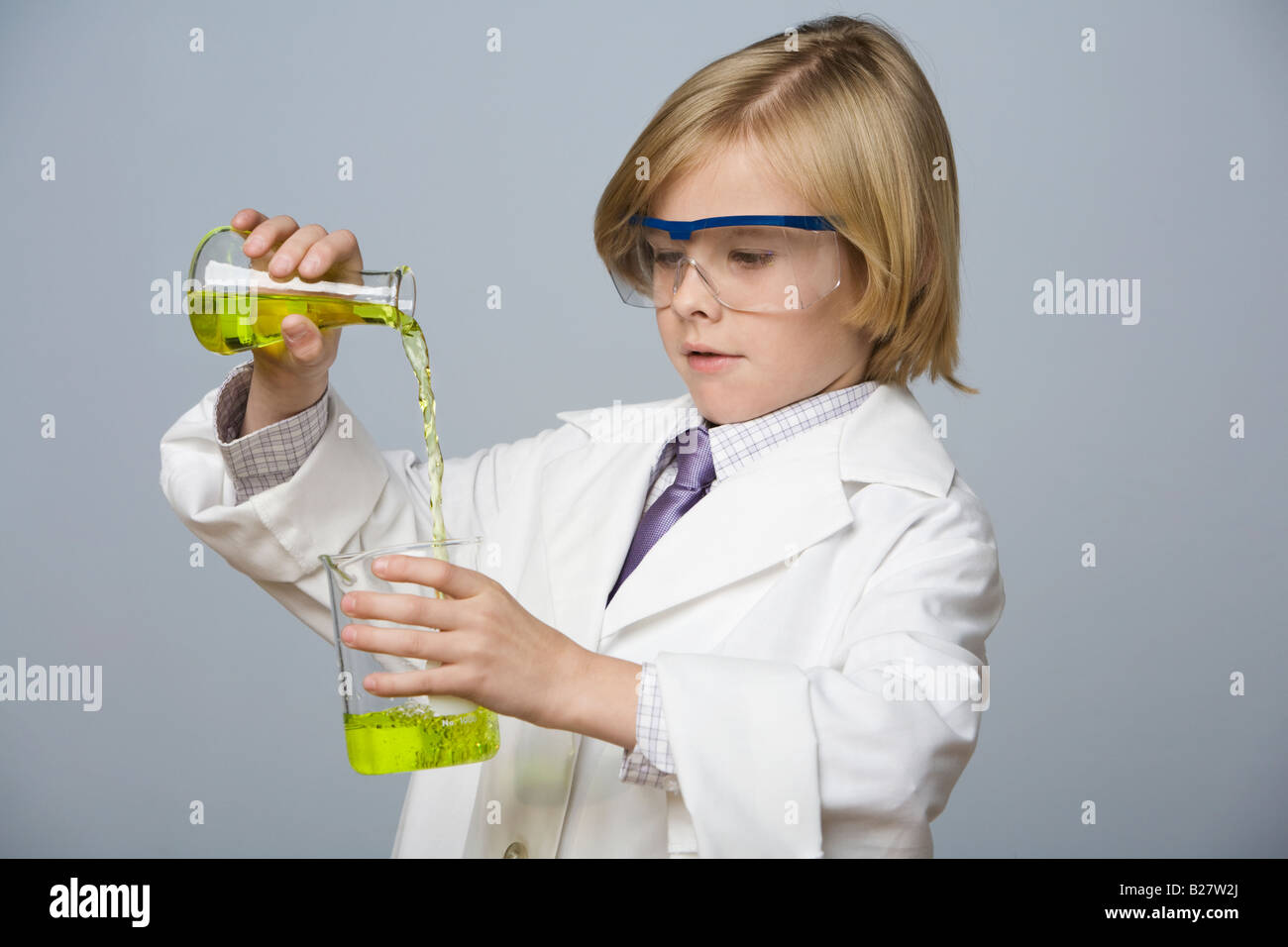 Boy pouring liquid into beaker Banque D'Images