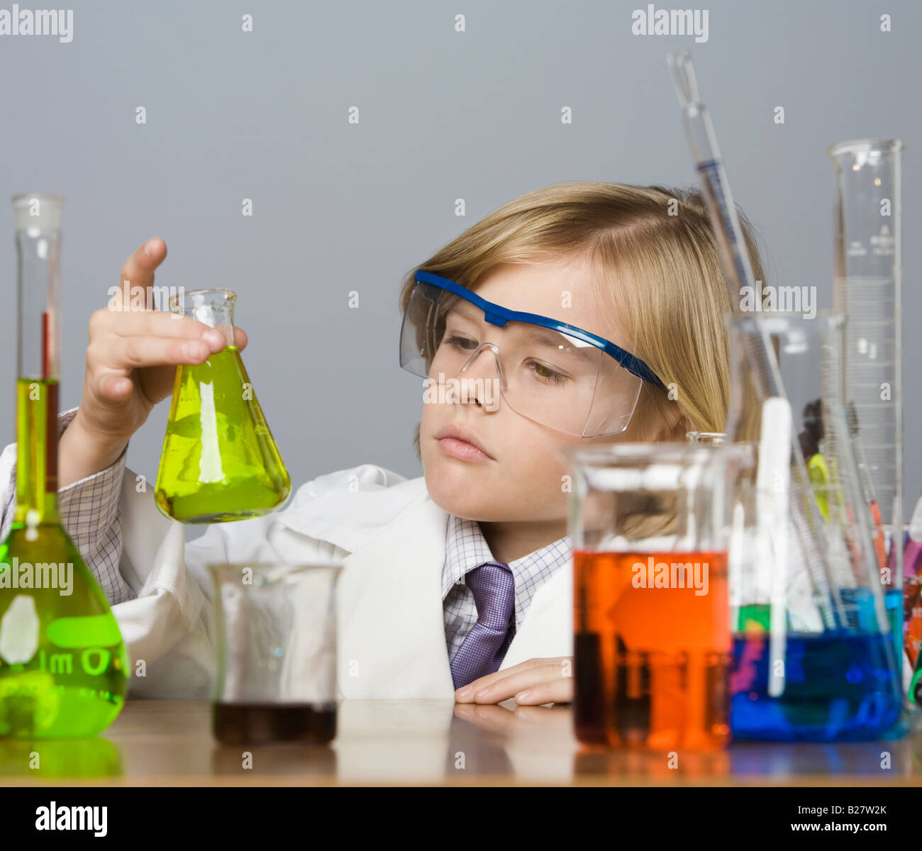 Boy looking at bécher rempli d'un liquide Banque D'Images