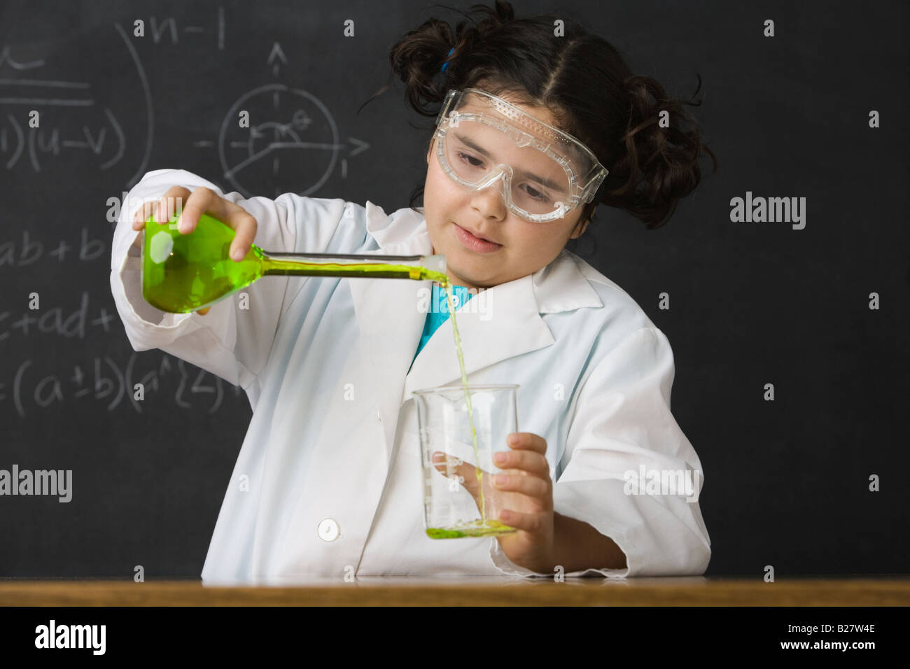 Girl pouring liquid in science class Banque D'Images