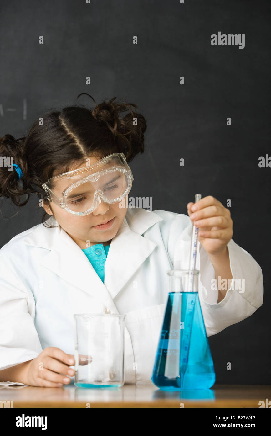 Girl measuring liquid in science class Banque D'Images