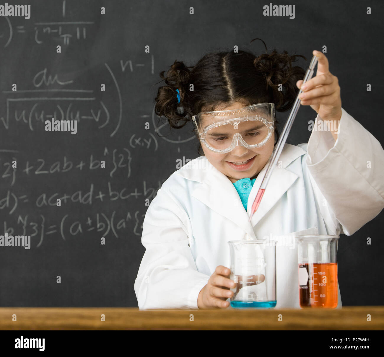 Girl measuring liquid in science class Banque D'Images