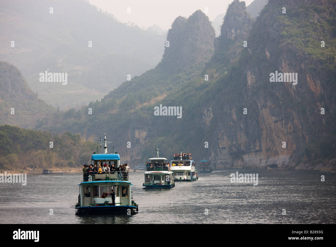Bateaux de touristes voyagent le long de la rivière Li de Guilin et Yangshuo Chine entre Banque D'Images