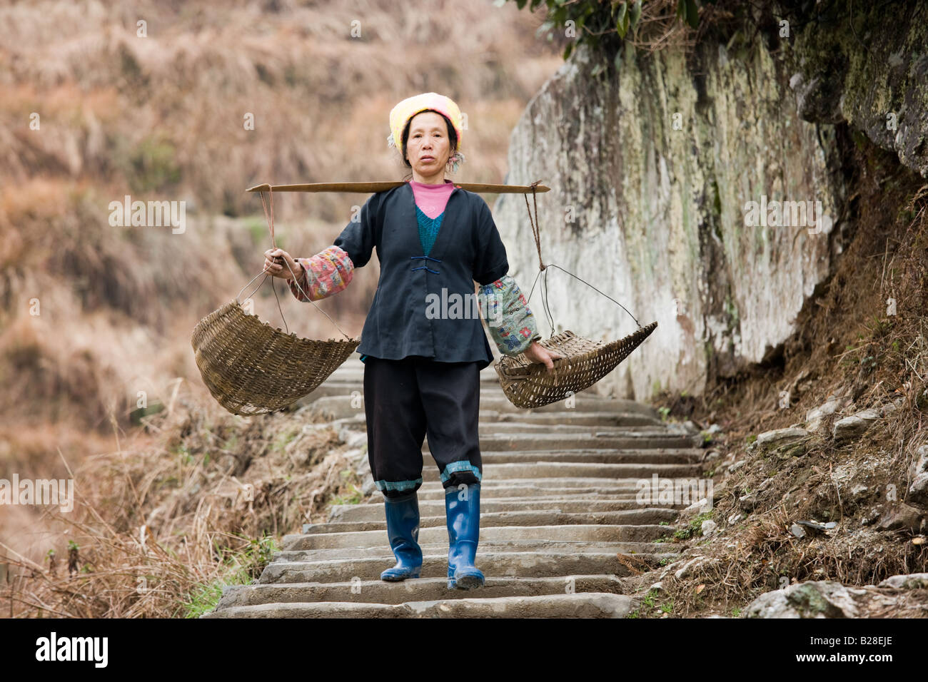 Femme portant des paniers de terrasse sur le domaine de Longsheng par village mountian de Ping An Chine Guilin Banque D'Images