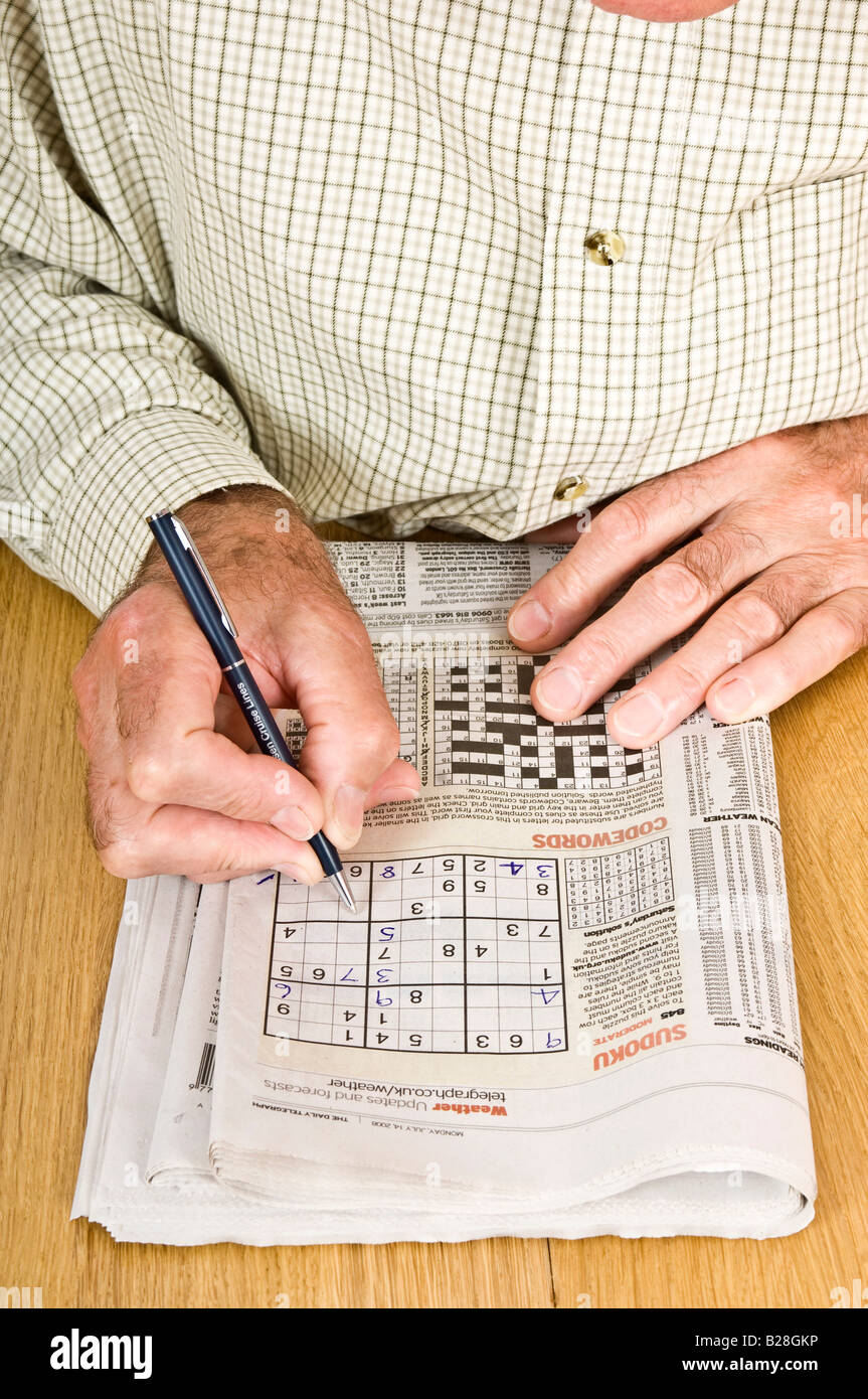 Un homme âgé se concentrant sur une grille de Sudoku dans un journal Photo  Stock - Alamy