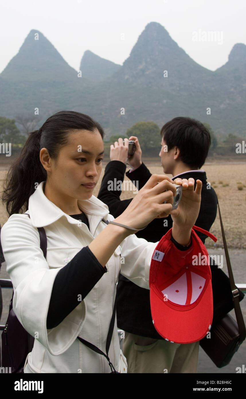 Les touristes de prendre des photos alors qu'ils se déplacent en bateau le long de la rivière Li de Guilin et Yangshuo Chine entre Banque D'Images