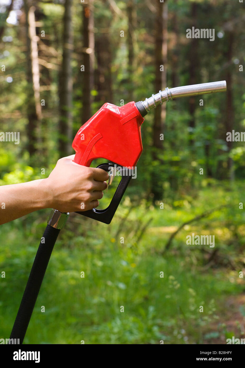 Main tenant un pistolet de distribution de gaz dans la forêt Banque D'Images