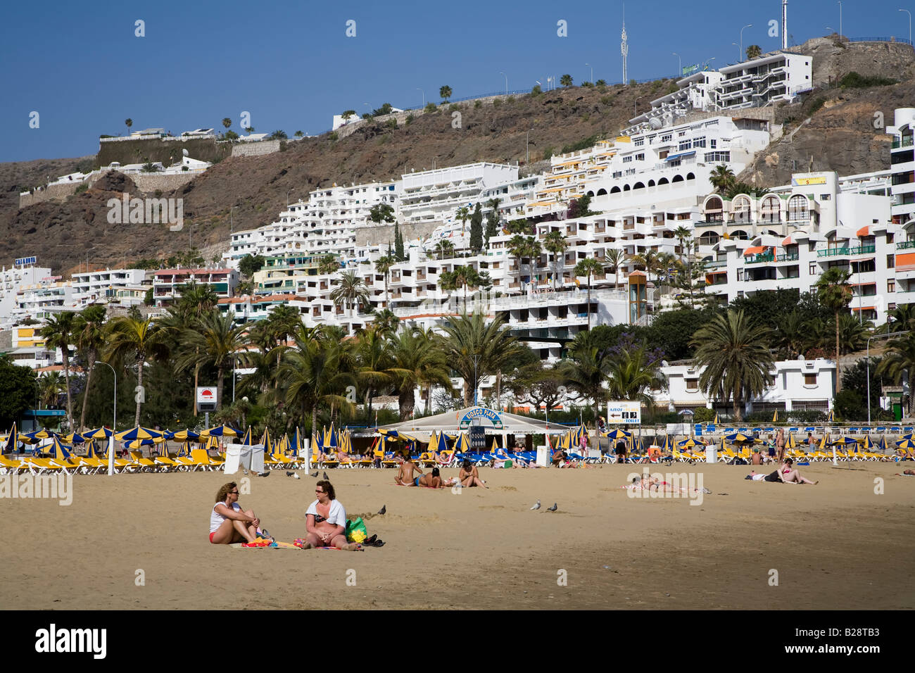 Les gens sur la plage avec Holiday Resort Apartments sur hill Porto Rico Gran Canaria Espagne Banque D'Images