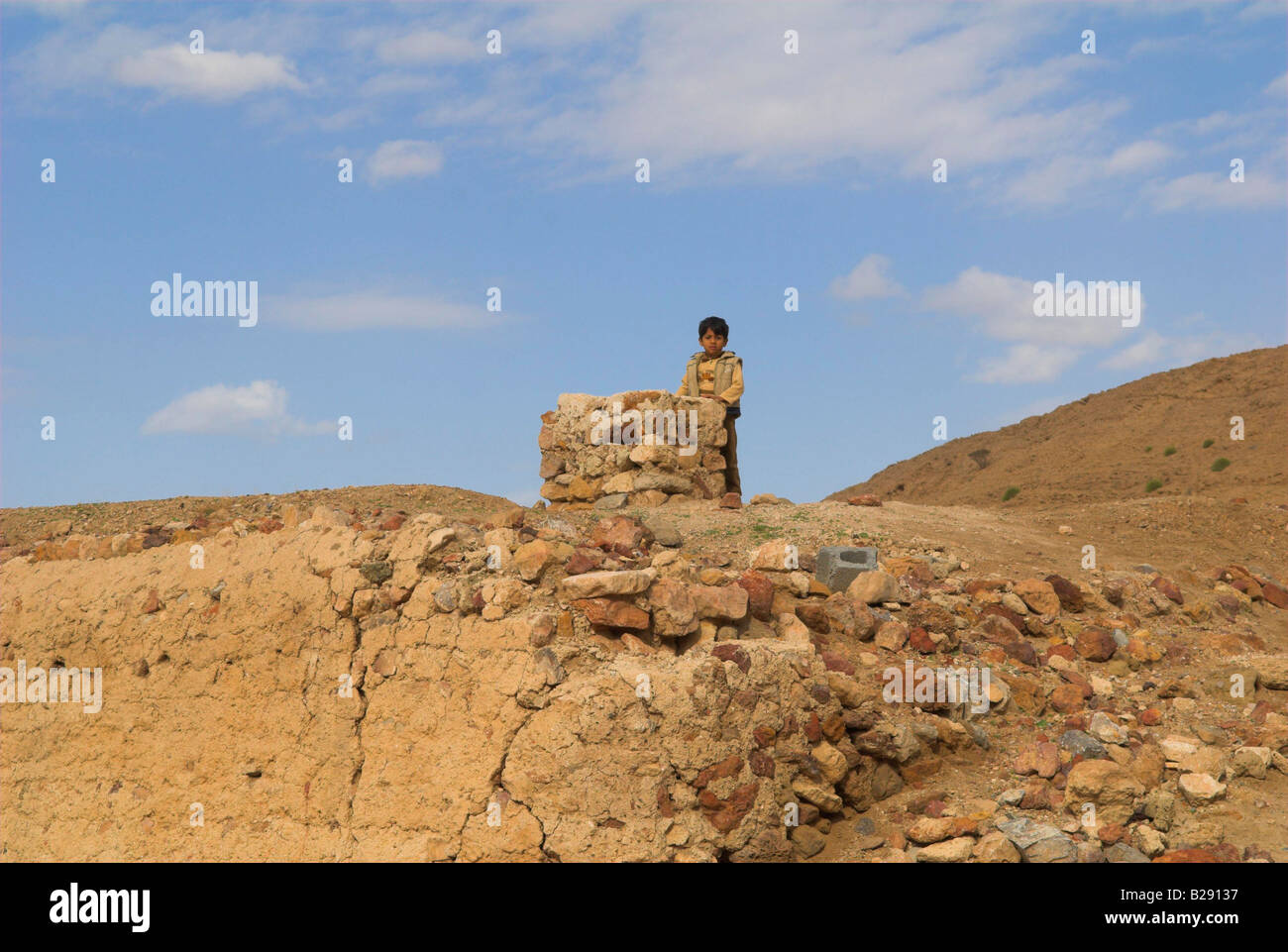 Petit garçon ancien bâtiment en brique de boue joue Ghala village près de Muscat Oman Banque D'Images