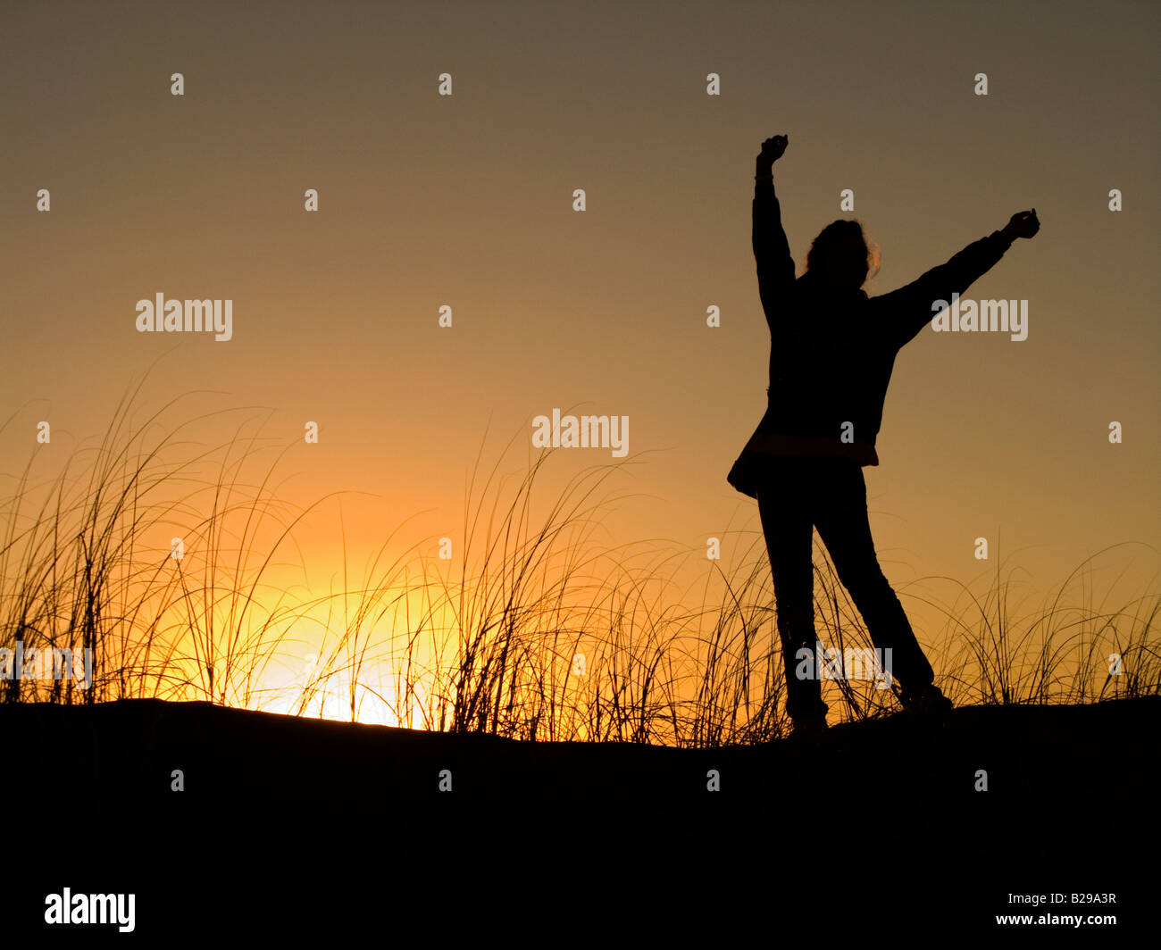 Silhouette d'une jeune fille adolescente danse avec un ciel de coucher du soleil à l'arrière-plan Banque D'Images