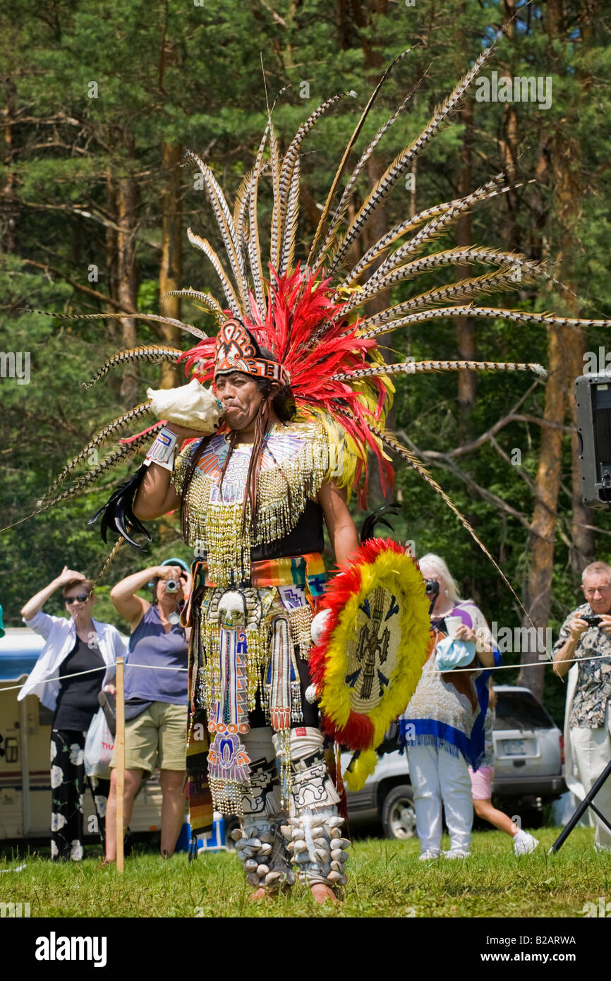 Aztec dancer performing soufflant conque au festival indien en fonda l'État de New York Banque D'Images