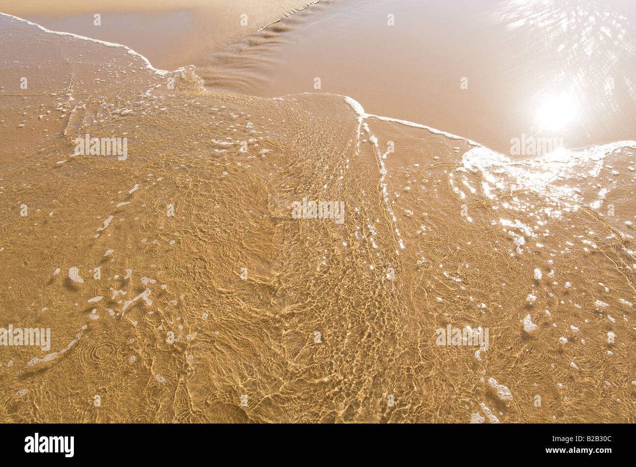 Miroir soleil dans le sable humide de l'été à la plage Banque D'Images