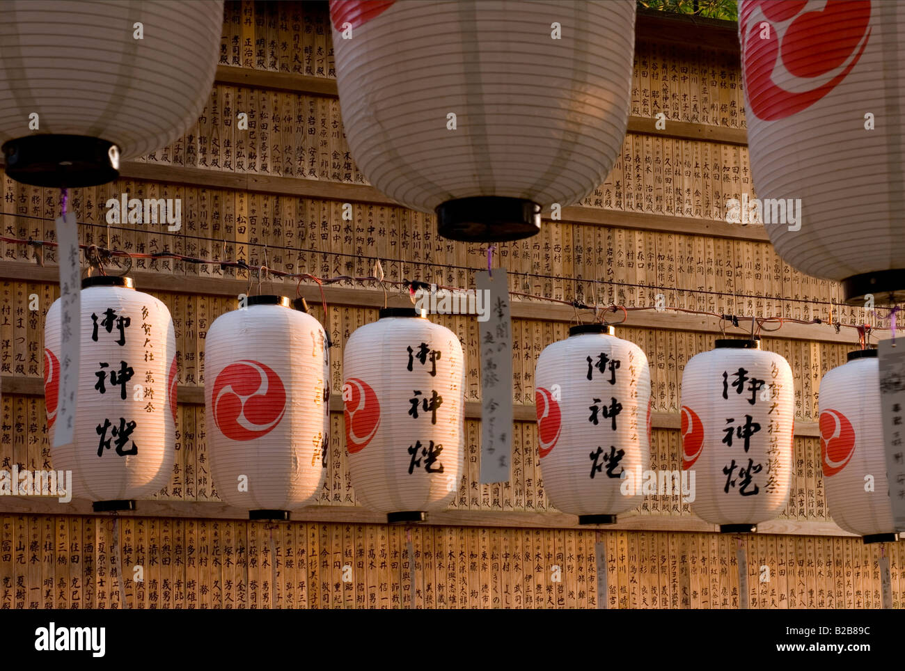 Groupe de papier suspendues à des lanternes festival Taga Taisha à Hikone attraper la lumière chaude soirée Banque D'Images