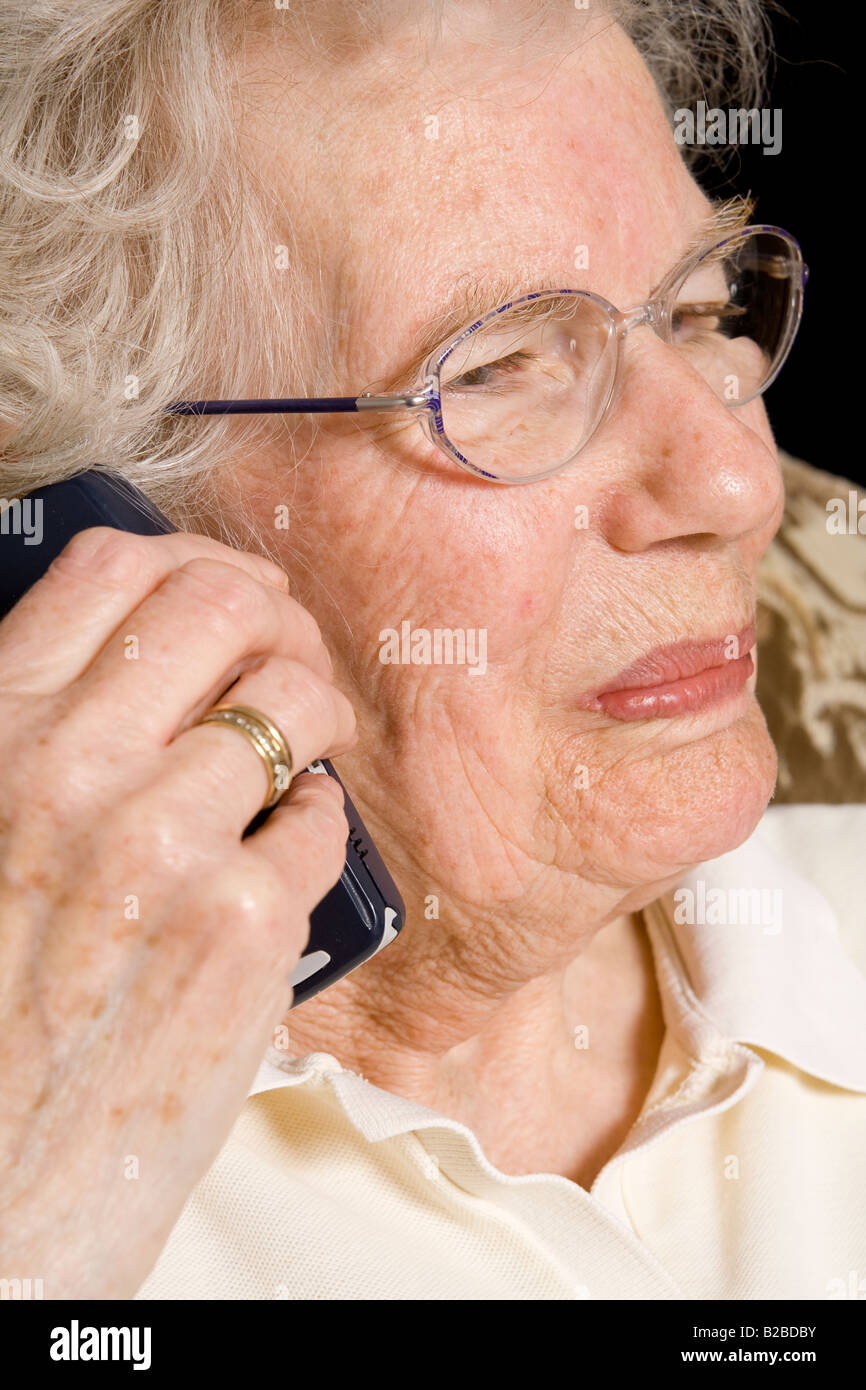 Une vieille femme à l'aide d'un téléphone portable, au Royaume-Uni. Banque D'Images