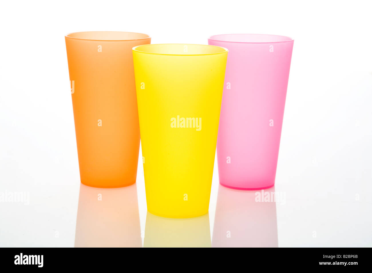Regroupement de trois verres en plastique colorés sur fond blanc Banque D'Images
