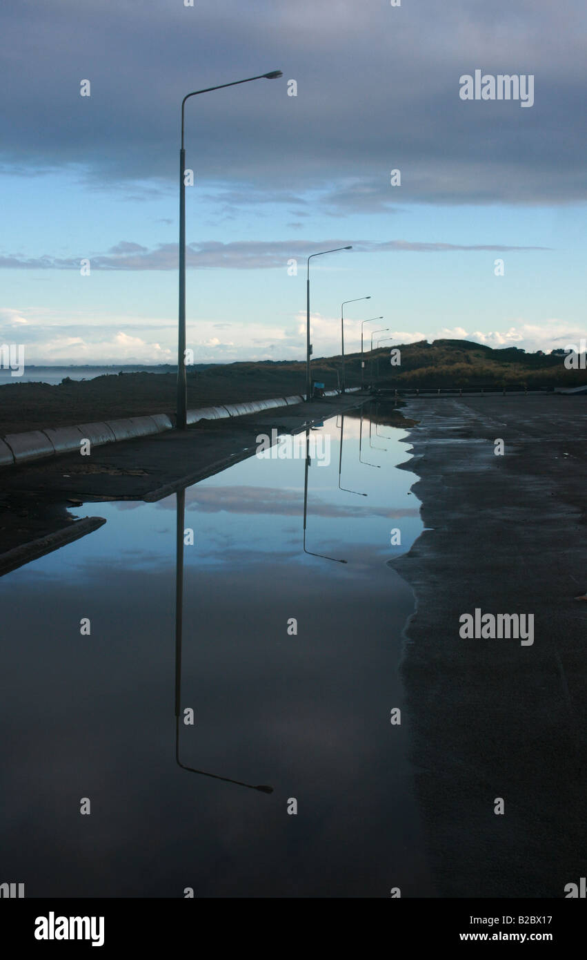 Réverbères reflète dans une flaque à la plage à Wanganui Castlecliff,, en Nouvelle-Zélande. Banque D'Images