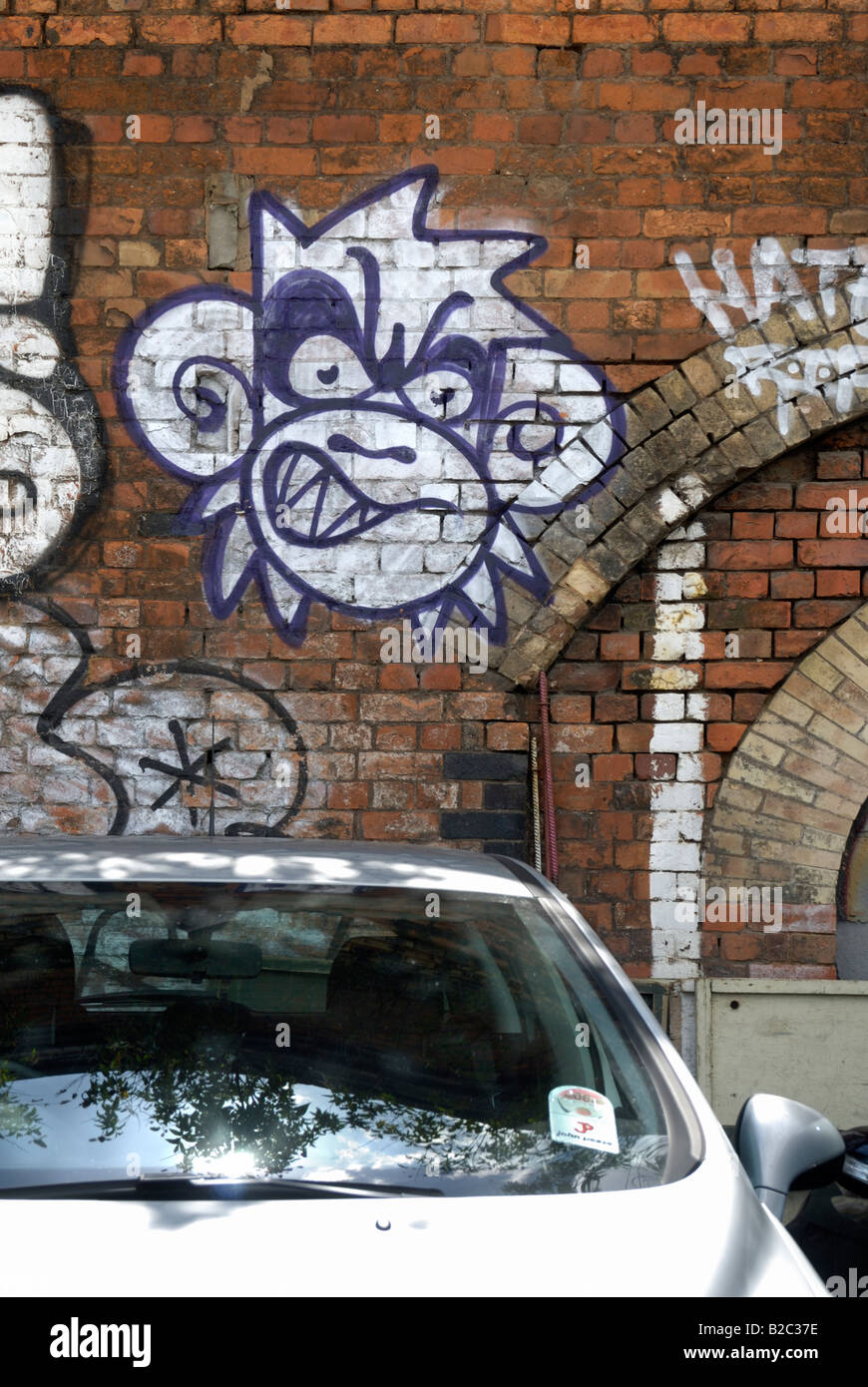 Voiture garée en face d'une peinture murale d'un singe sur le mur de briques, Londres Banque D'Images