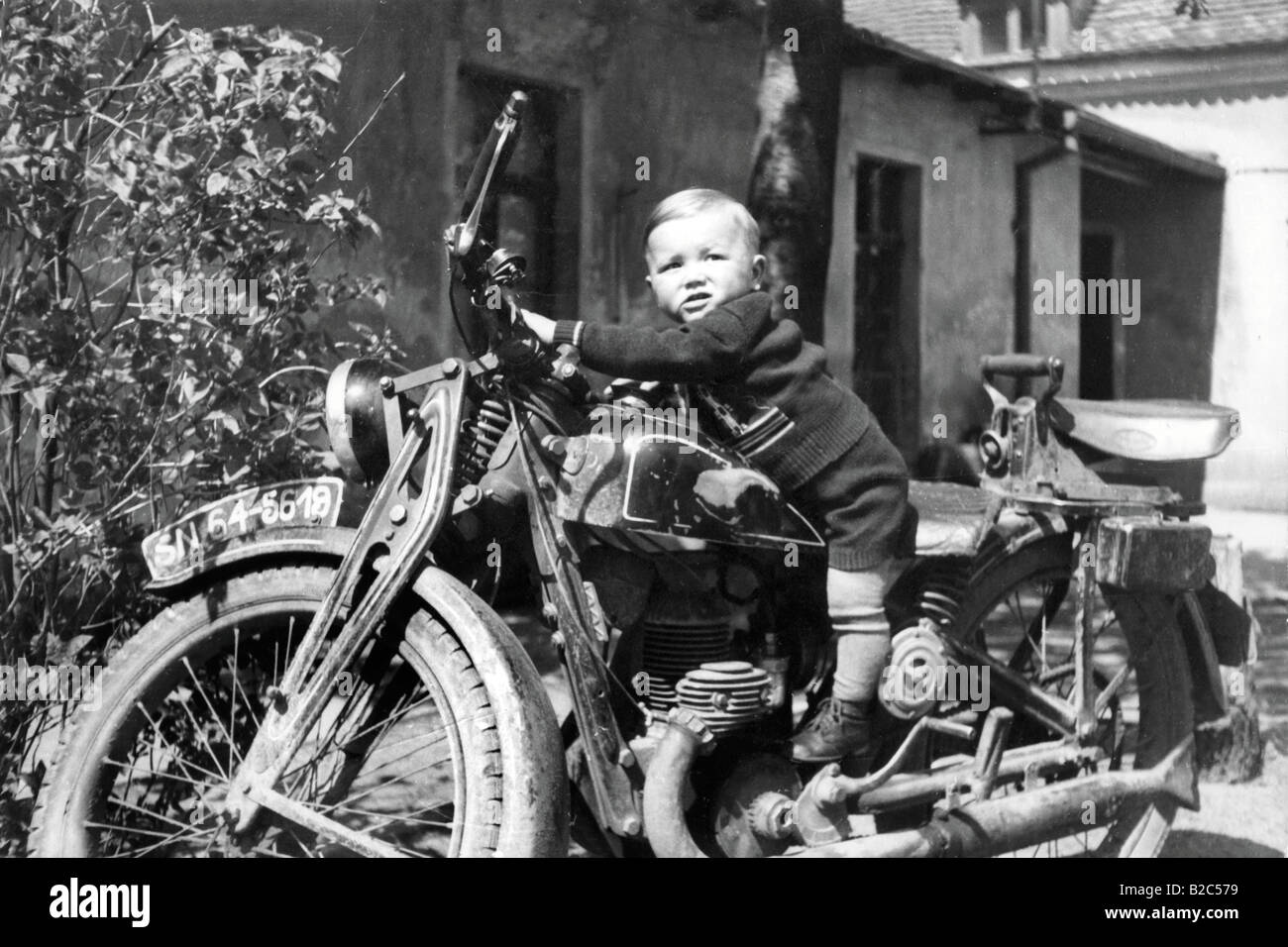Petit enfant sur une moto, photo historique, vers 1940 Banque D'Images