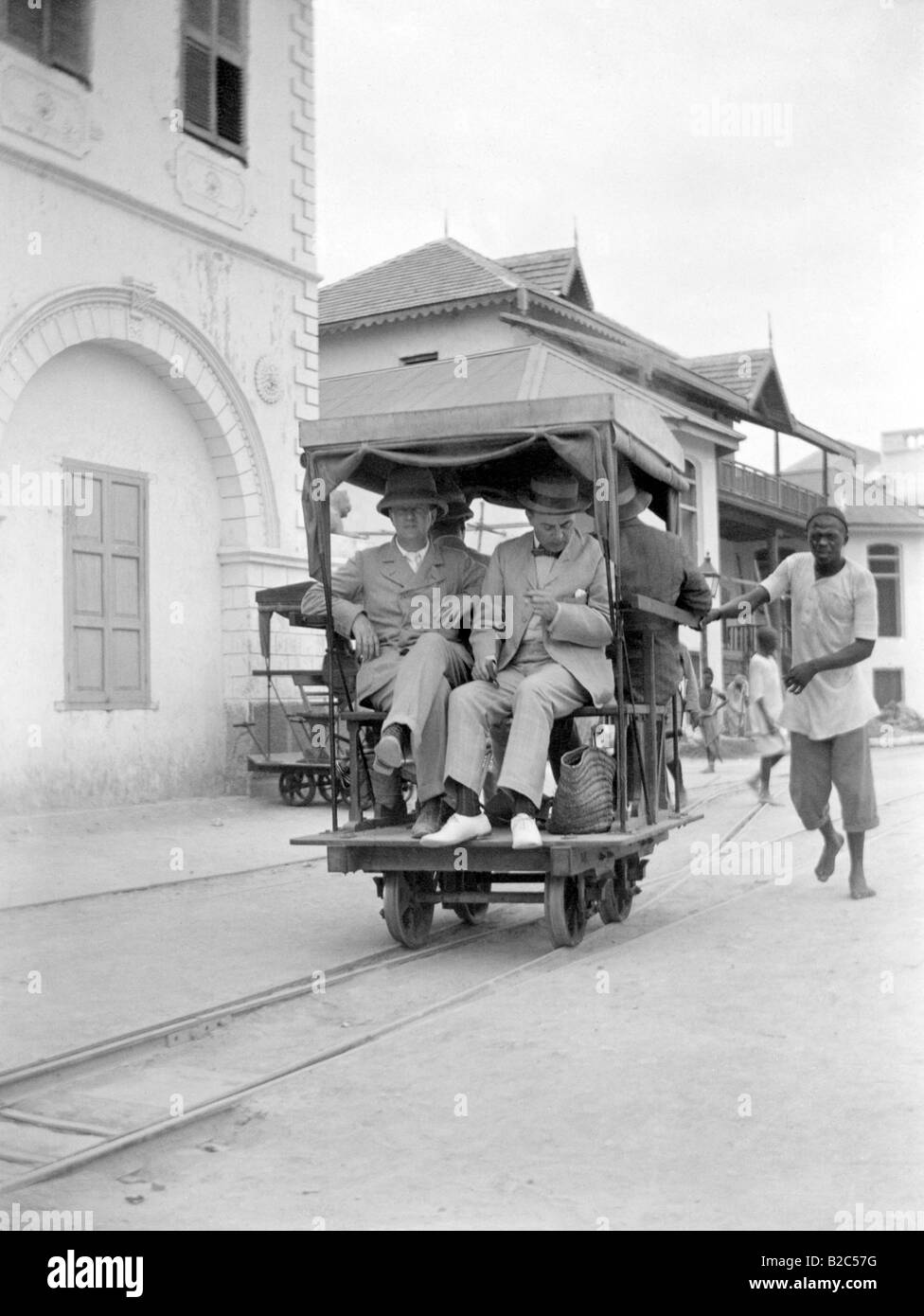 Eurpeans africaine poussant dans un véhicule ferroviaire, photo historique, vers 1920 Banque D'Images
