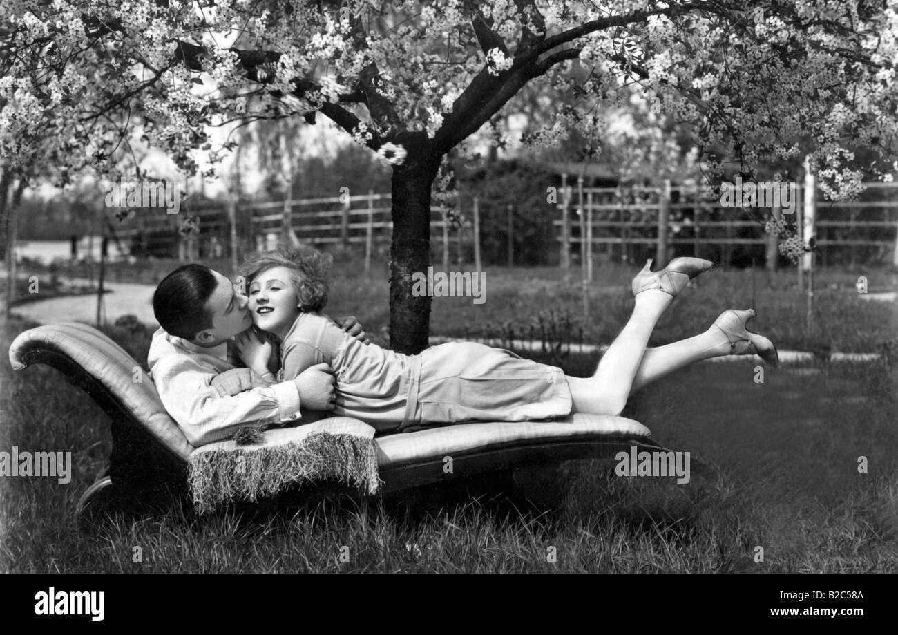 L'homme et la femme se trouvant à l'extérieur, sur un canapé, photo historique d'environ 1910 Banque D'Images