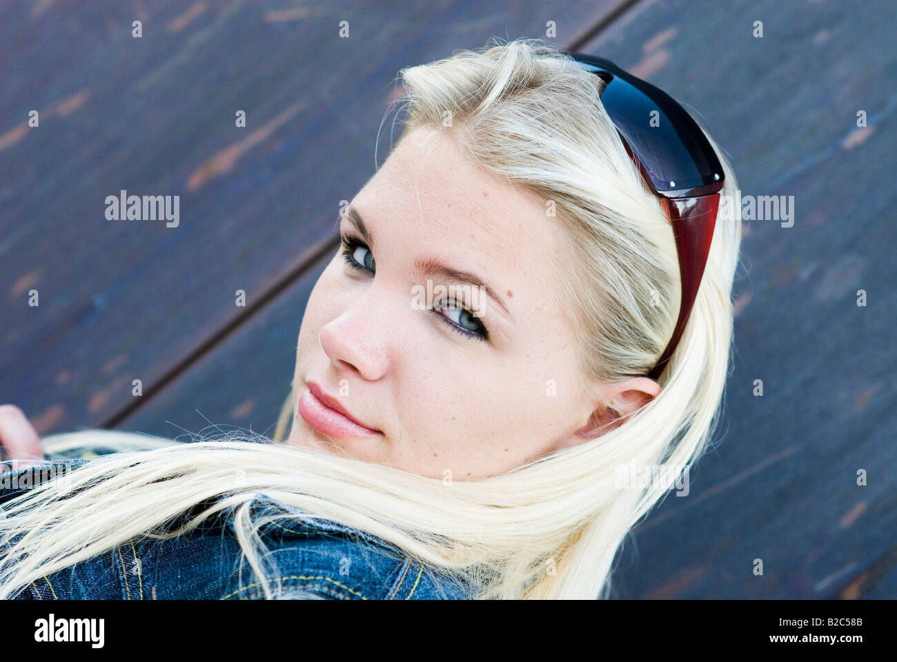 Jeune femme blonde avec des lunettes à rusty metal wall Banque D'Images