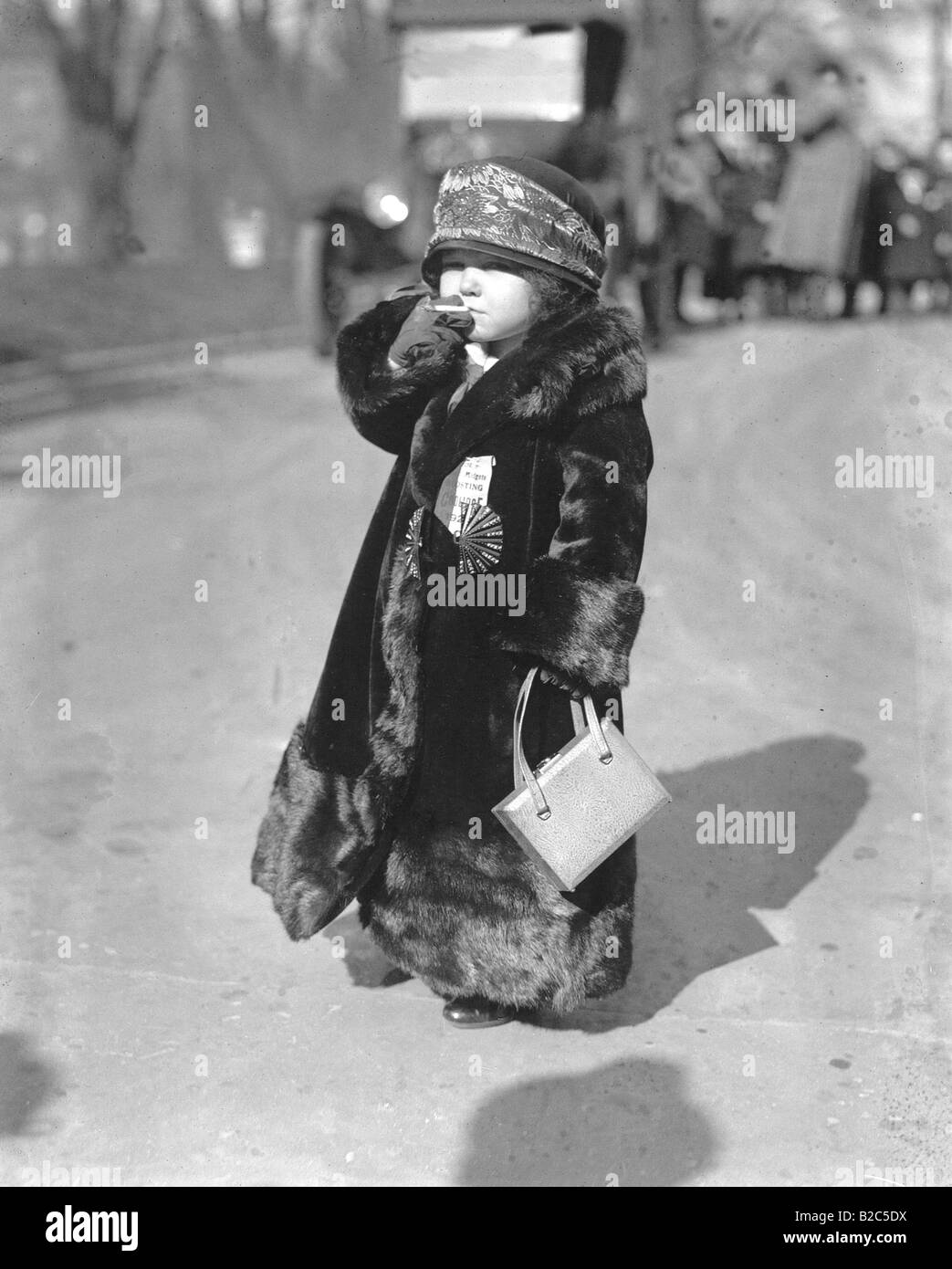 Enfant portant un manteau de fourrure, de fumer la cigarette, photo historique d'environ 1920 Banque D'Images