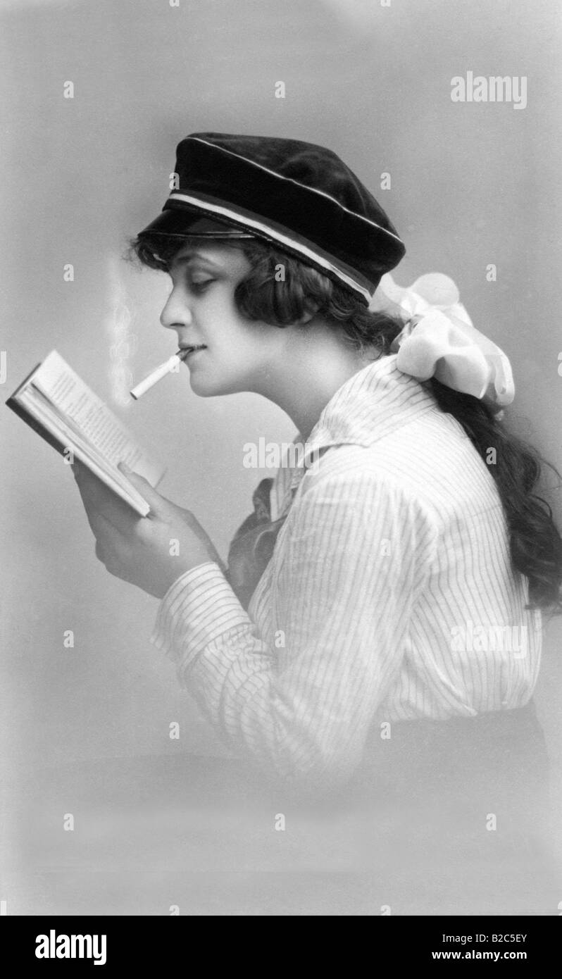 La jeunesse moderne, femme fumant cigarette et lecture, photo historique d'environ 1910 Banque D'Images