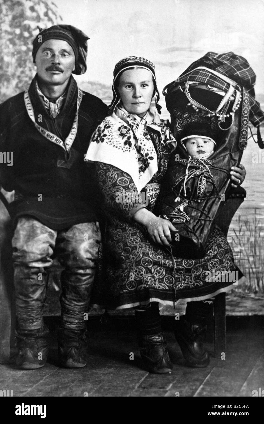 Le port de vêtements traditionnels sami, tenant un bébé, photo historique d'environ 1920, en Suède, Scandinavie, Europe Banque D'Images