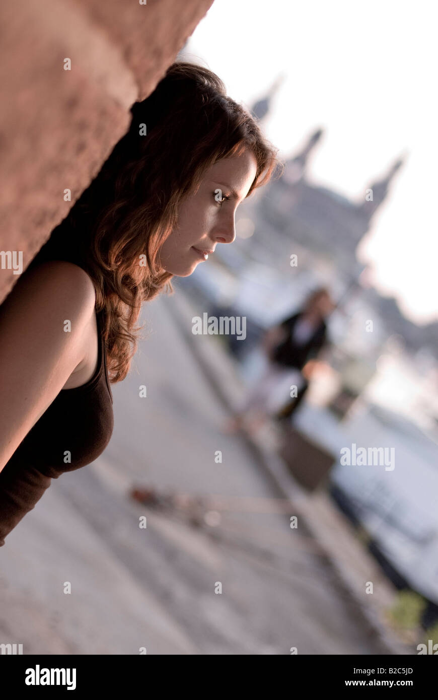 Cute brown-haired woman leaning against a wall Banque D'Images