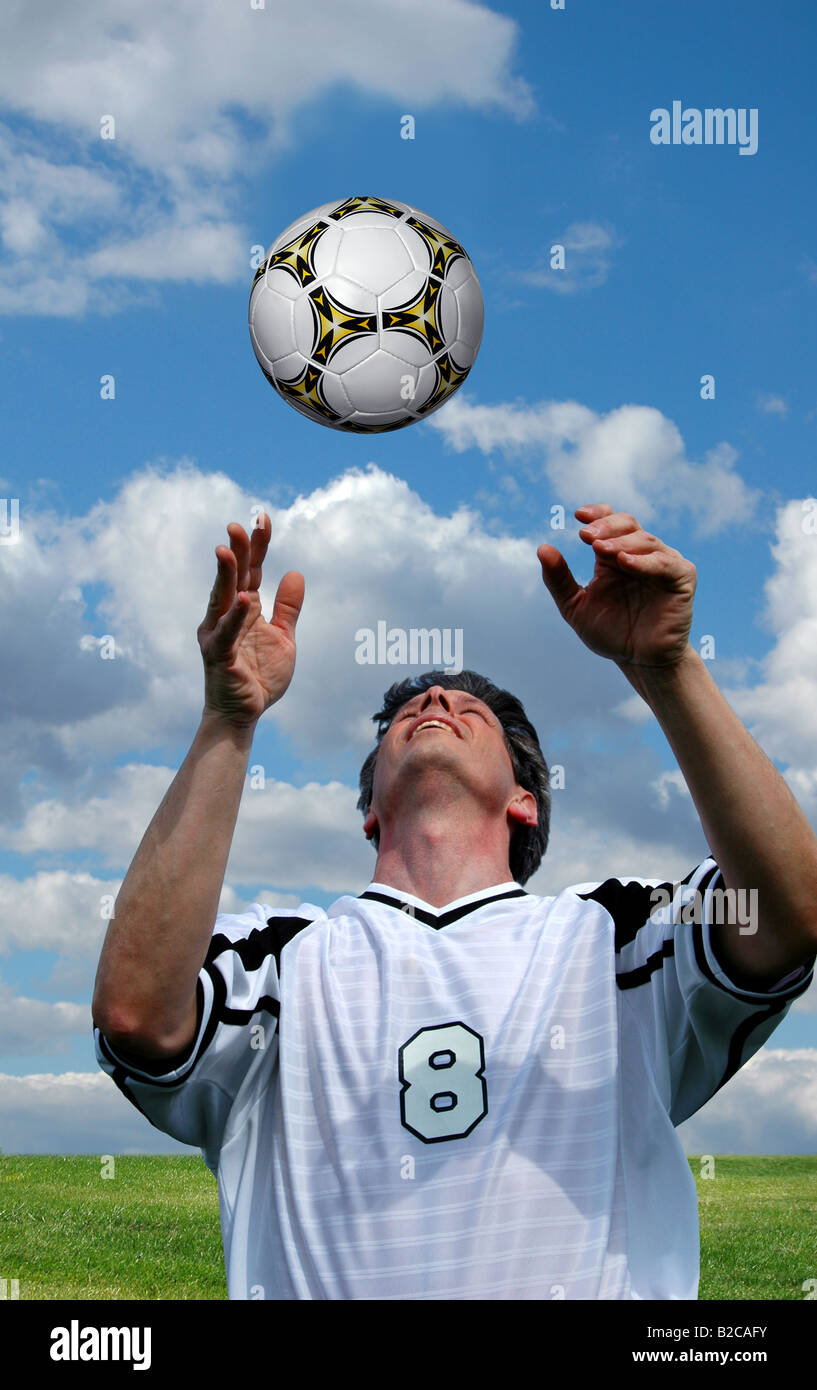 Le joueur de soccer Football tête plus d'un ciel lumineux Banque D'Images