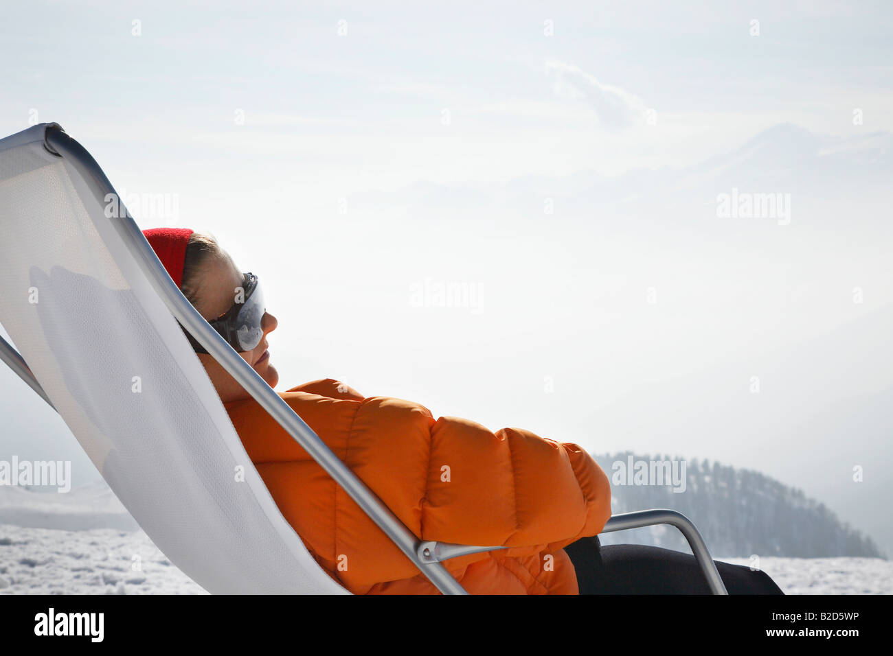 Personne assise dans la chaise de parterre dans la neige Banque D'Images