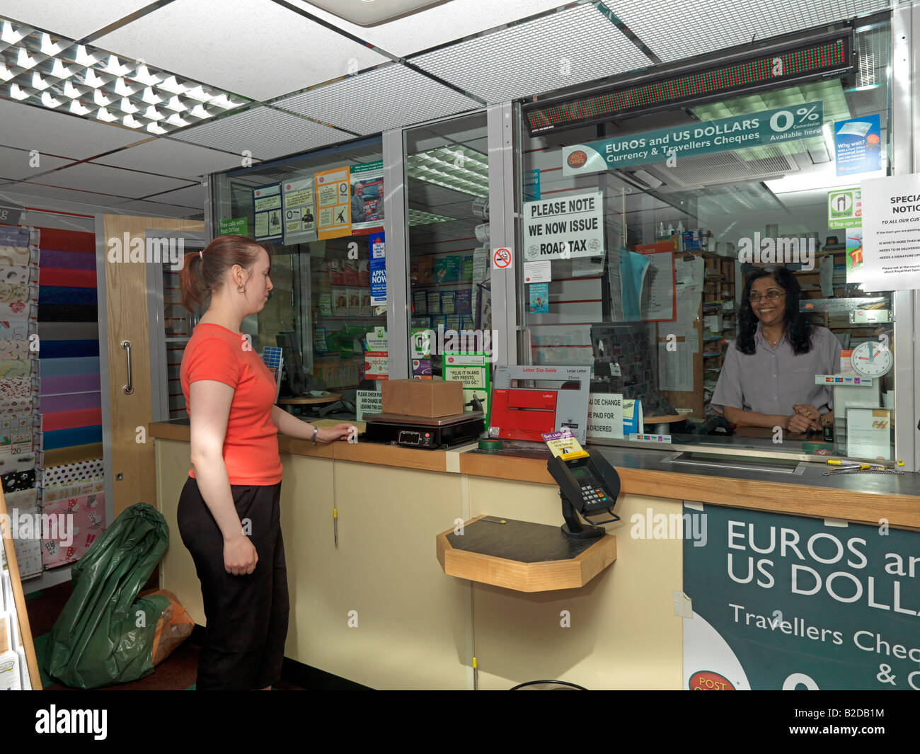 1002870 Une femme pesant colis en bureau de poste Banque D'Images