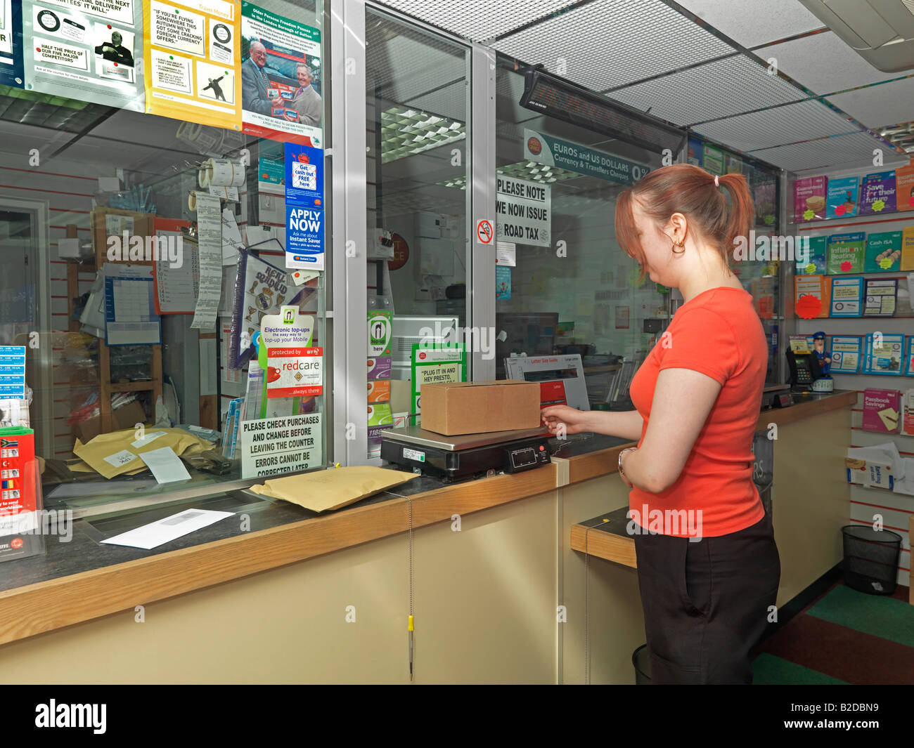 Femme pesant un colis au bureau de poste Banque D'Images