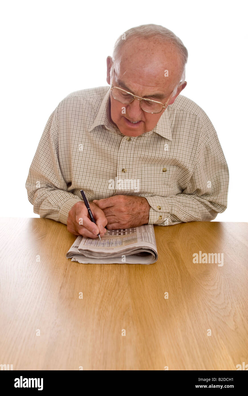 Portrait vertical d'un vieux monsieur de faire le puzzle Sudoku dans son quotidien Banque D'Images