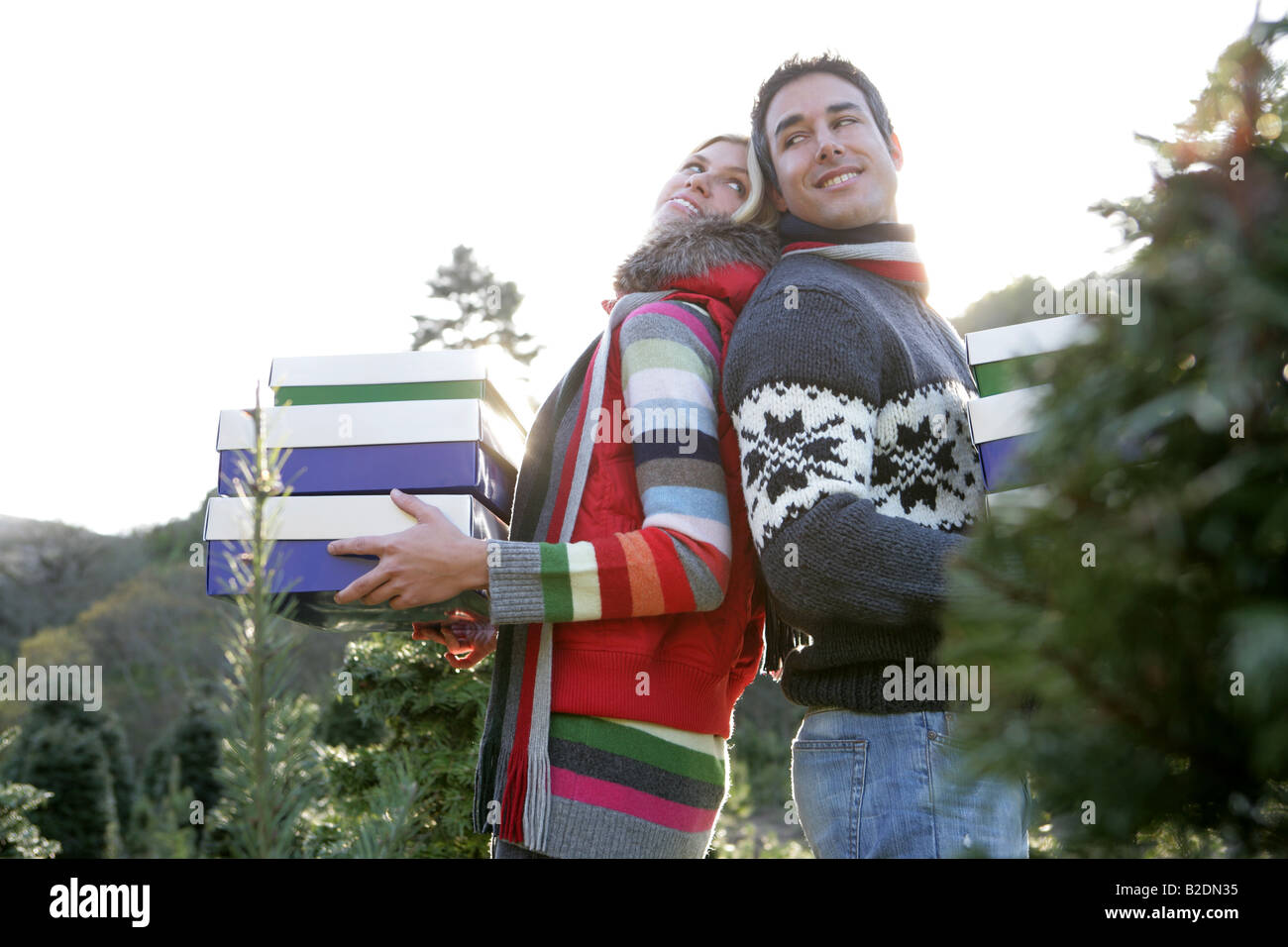 Jeune couple avec cadeaux de Noël à l'extérieur. Banque D'Images