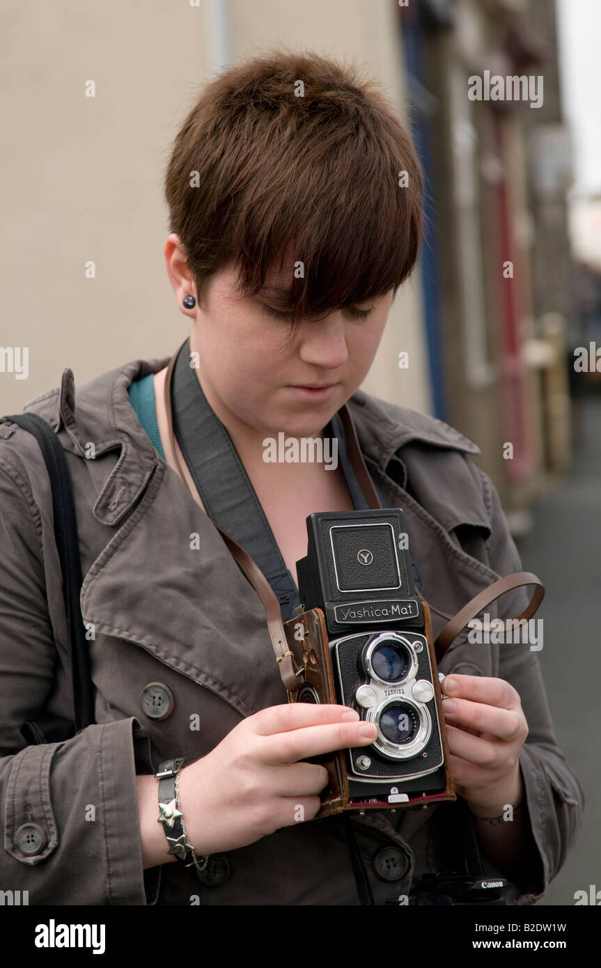 Jeune femme photographe étudiant Université d'Aberystwyth en utilisant un vieux Reflex Bi-objectif Yashica Mat film appareil moyen format Banque D'Images