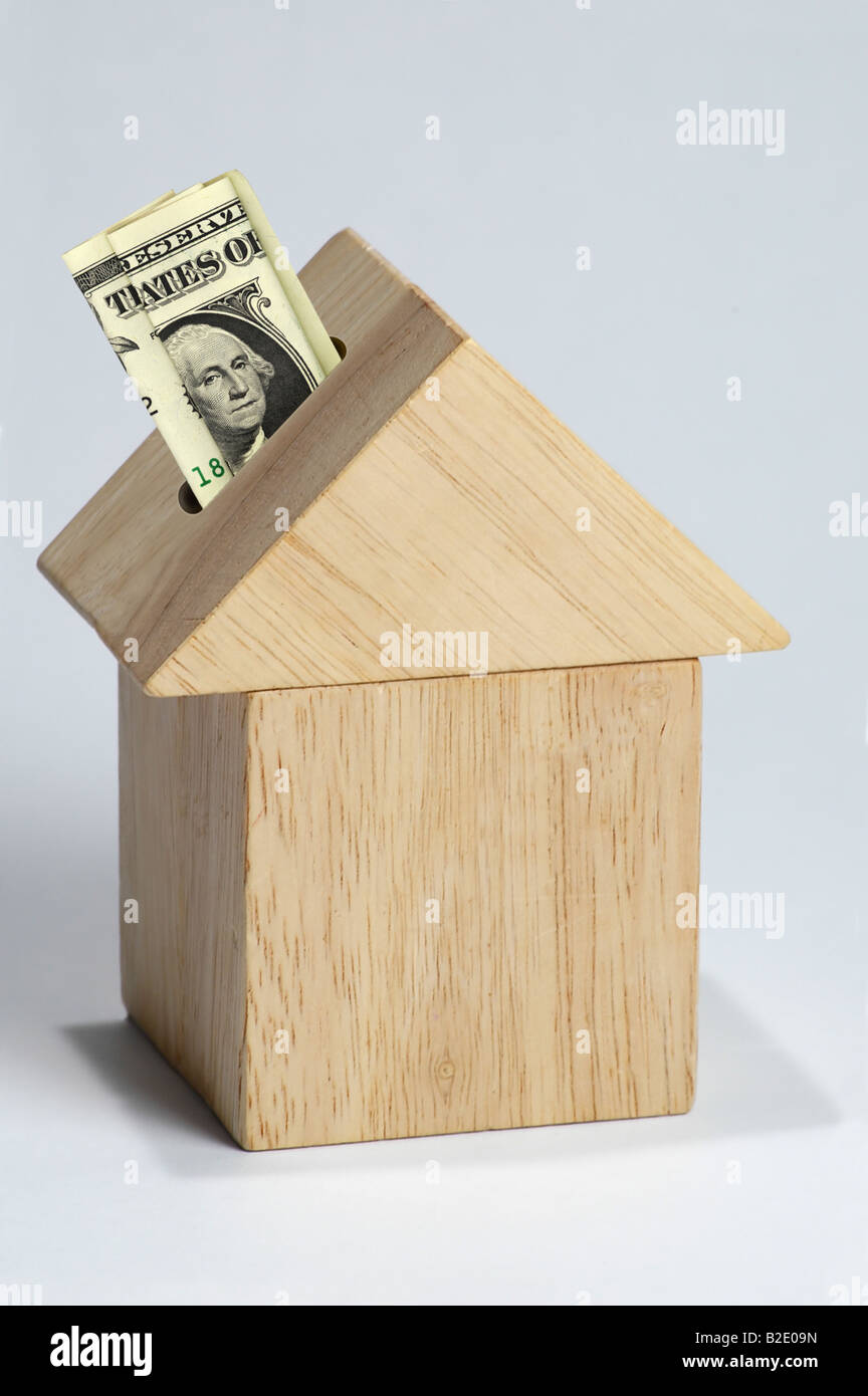 Maison en bois comme tirelire avec dollar bill Banque D'Images
