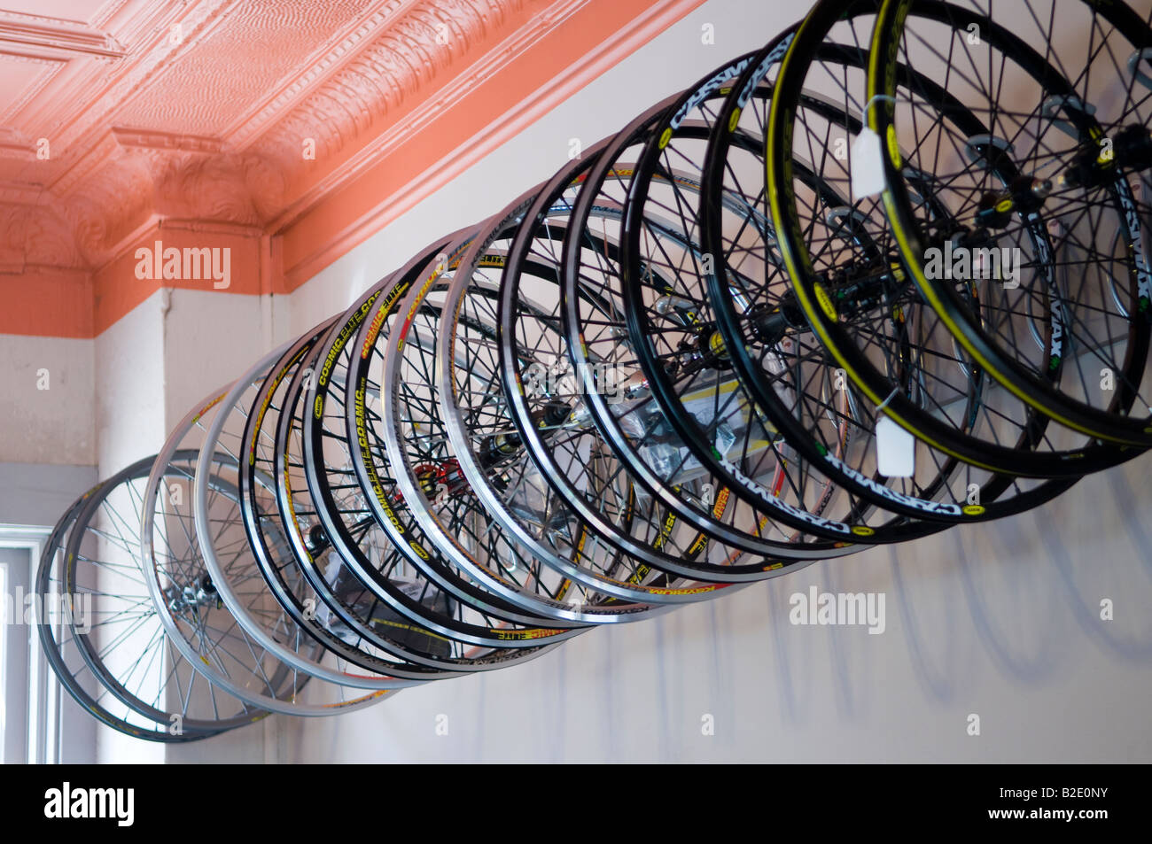 Roues vélo de route léger accrocher dans un groupe sur le mur dans un cycle shop Banque D'Images
