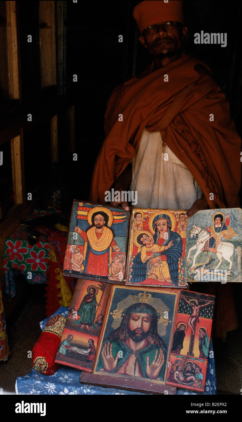 Un prêtre à l'Église Kebran Gabriel montre plusieurs de ses nombreux anciens livres illustrés. Banque D'Images