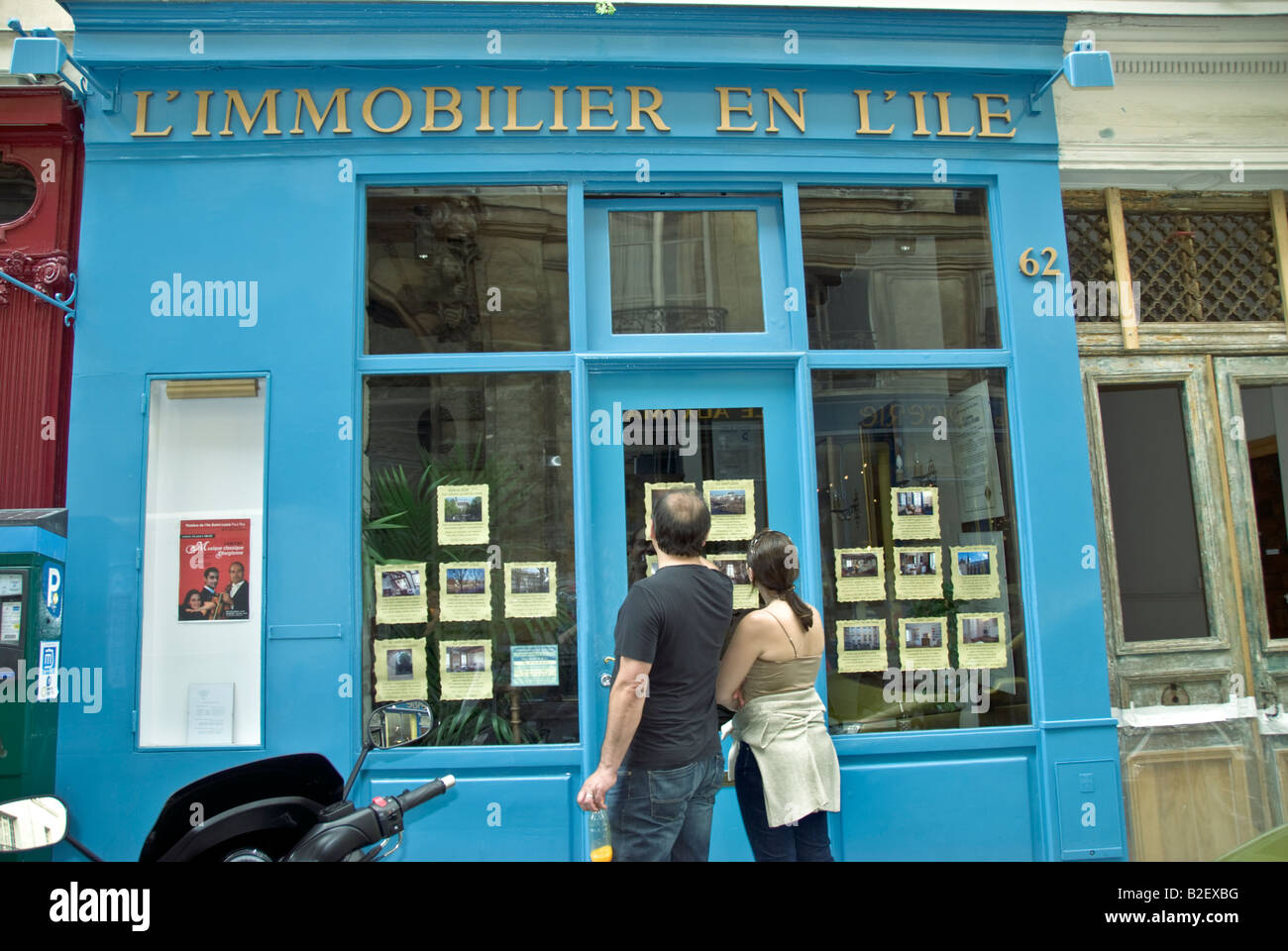 Paris France, couple Window Shopping pour les appartements à la recherche dans l'ancienne boutique française Front of Real Estate Agent Window, marché immobilier, signes vintage, Banque D'Images
