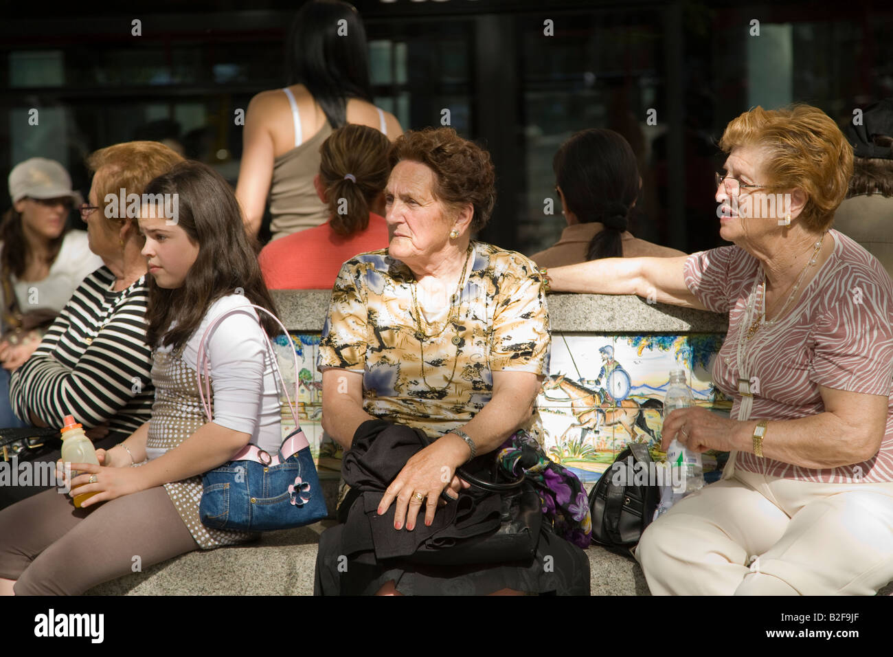 Espagne Toledo deux femmes âgées et d'adolescente s'asseoir sur un banc dans la zone de plein air populaires Plaza Zocodover Banque D'Images