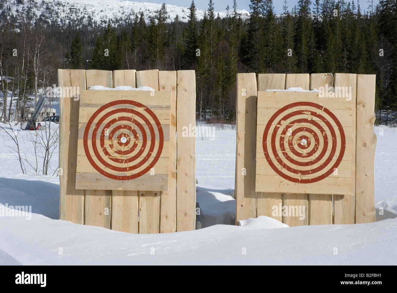 Paire de cibles en bois dans la neige avec un peu de marques faites par des flèches et des haches Banque D'Images