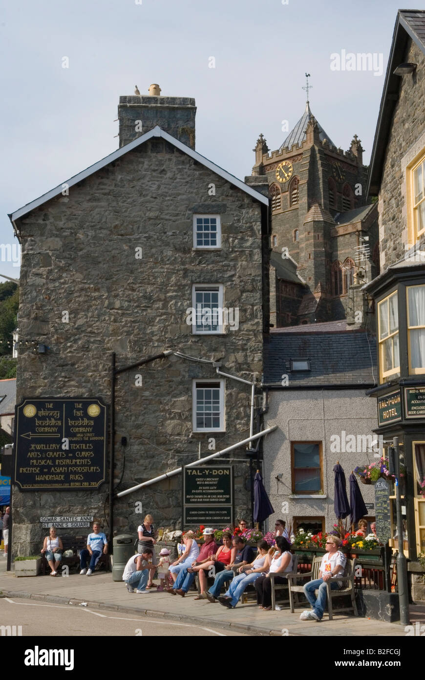 Barmouth Gwynedd pays de Galles touristes britanniques appréciant la chaleur de l'après-midi assis sur des bancs dans le centre de la station balnéaire. Côte ouest du nord du pays de Galles. HOMER SYKE. Banque D'Images