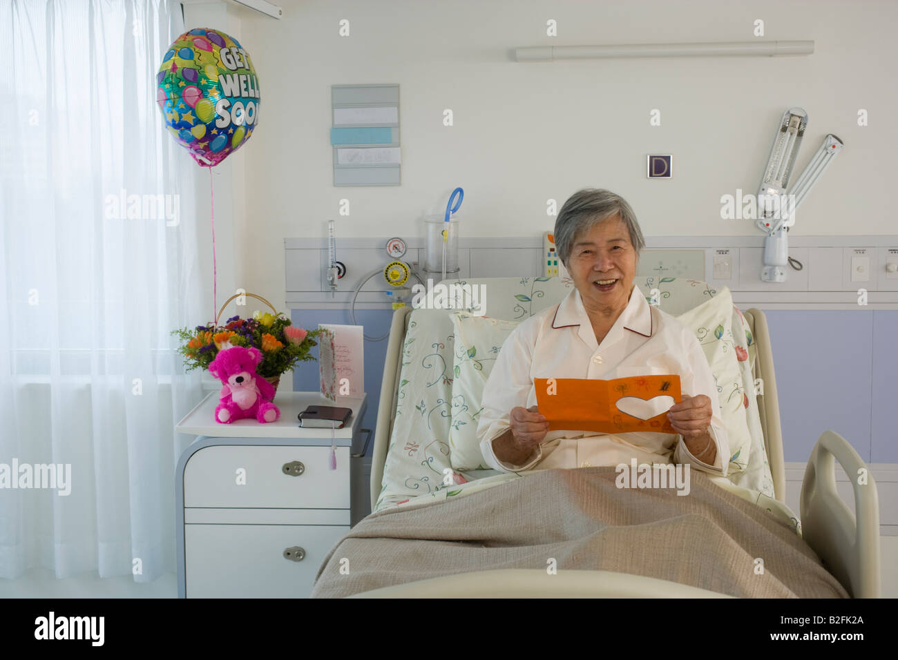 Portrait d'une femme lisant une carte de prompt rétablissement à l'hôpital Banque D'Images