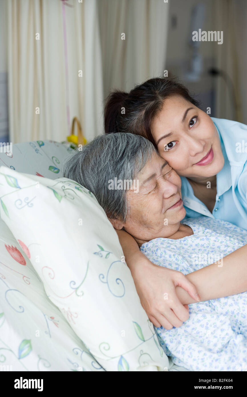 Portrait of a Mid adult woman hugging a female patient et souriant Banque D'Images