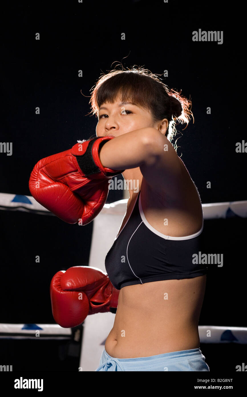 Jeune femme pratiquant la boxe dans un ring de boxe Banque D'Images